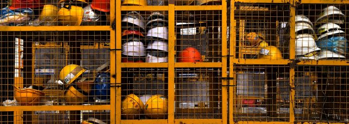a rack filled with lots of yellow hard hats